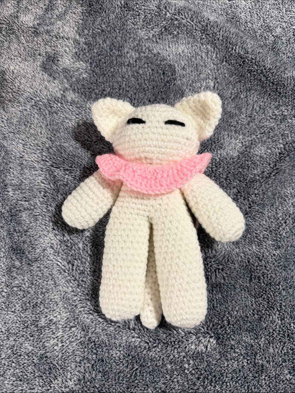 Handmade Cream Crochet Cat Plush with Pink Collar and bendable tail.